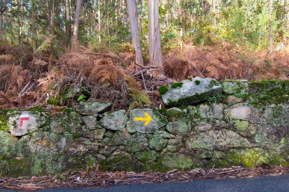 yellow arrow on stone wall